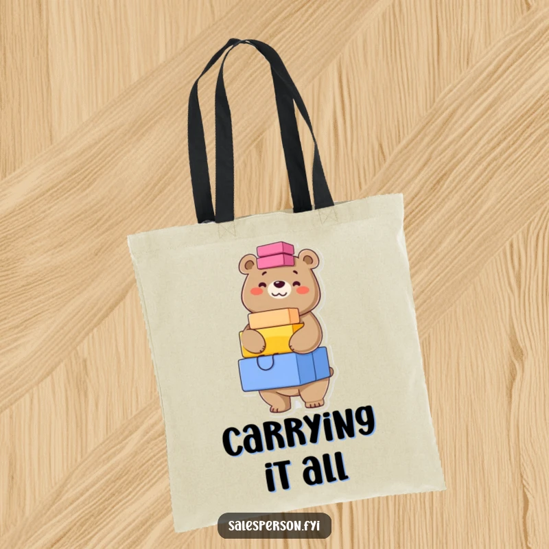 Funny tote bag showing a confident bear grinning while balancing a high stack of colorful boxes, ready for any load.