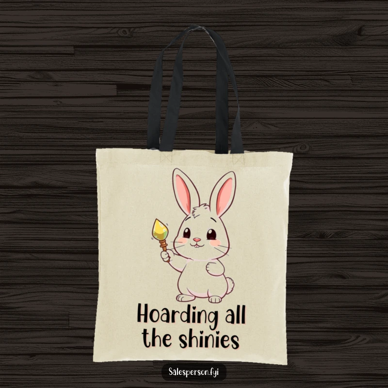 Funny tote bag featuring a curious rabbit proudly presenting a shiny, desirable object, perfect for carrying discoveries with style.